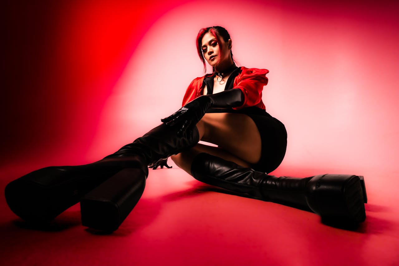 menu-02 Striking portrait of a fashion model in a red and black latex outfit with dramatic lighting.