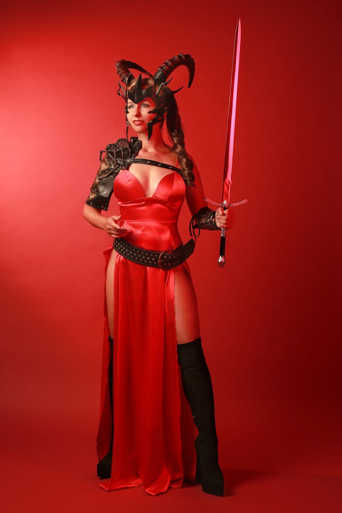 menu-12 A striking portrait of a woman in a red fantasy costume holding a sword, exuding elegance and mystery.